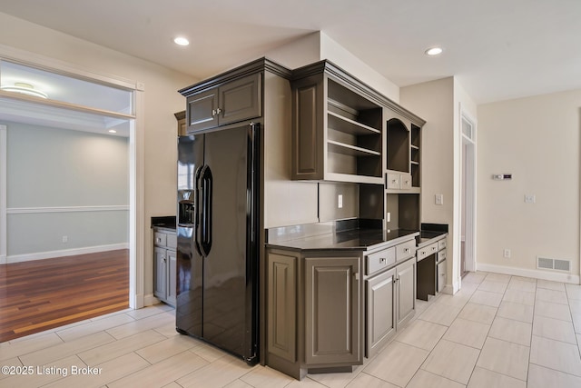 kitchen with visible vents, black fridge with ice dispenser, dark countertops, open shelves, and recessed lighting