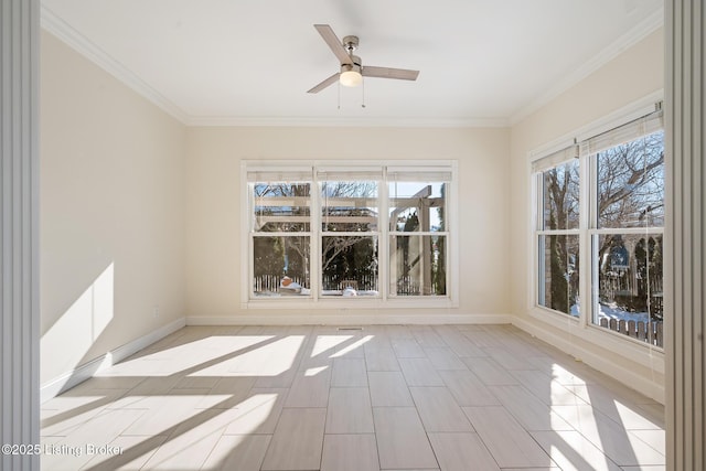 spare room with a ceiling fan, baseboards, and crown molding