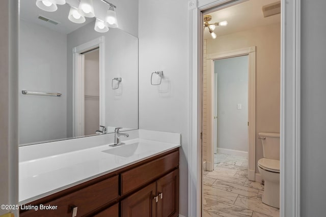 bathroom with toilet, marble finish floor, vanity, and visible vents