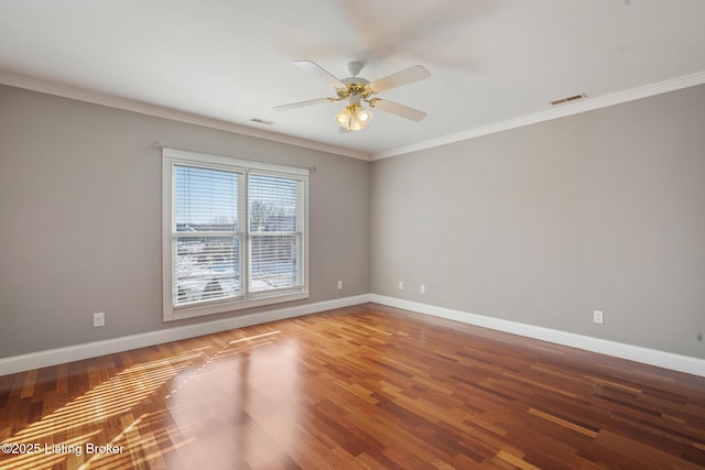 spare room featuring visible vents, baseboards, wood finished floors, and ornamental molding