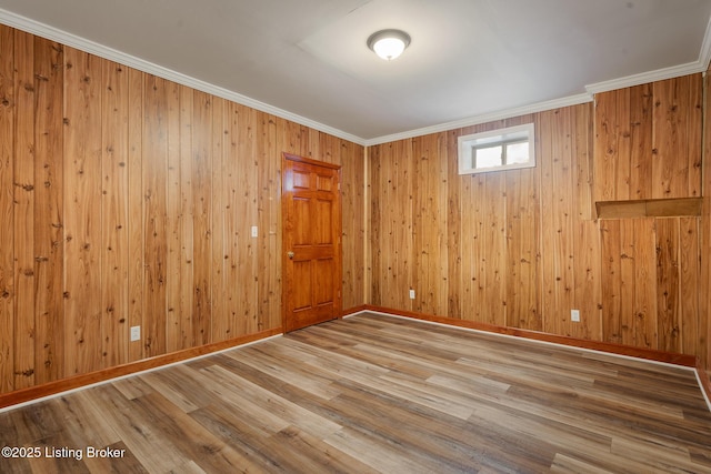 unfurnished room featuring crown molding, wood finished floors, and baseboards