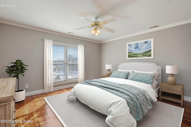 bedroom featuring baseboards, visible vents, wood finished floors, and ornamental molding