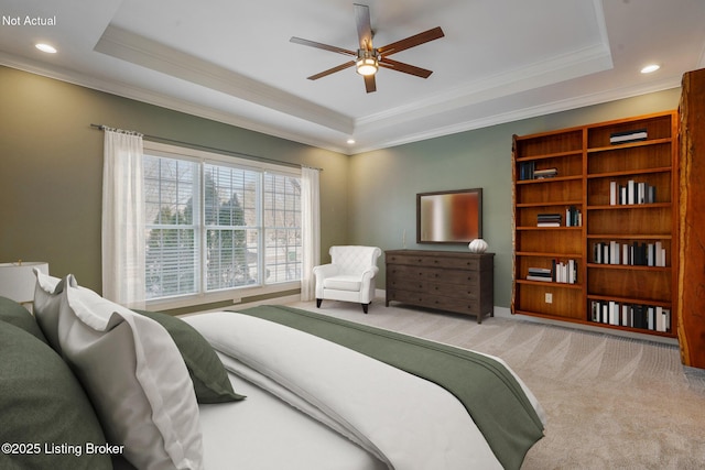 carpeted bedroom featuring a raised ceiling, crown molding, and ceiling fan