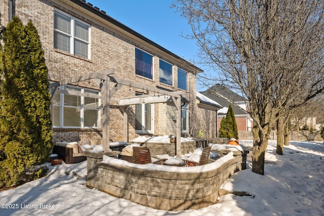 snow covered property featuring a pergola