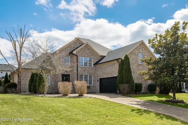 traditional home with driveway, a garage, a shingled roof, a front yard, and brick siding