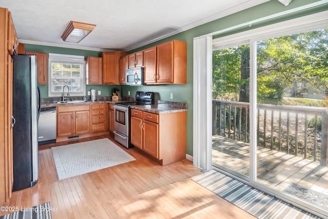 kitchen with light hardwood / wood-style floors, sink, appliances with stainless steel finishes, and ornamental molding