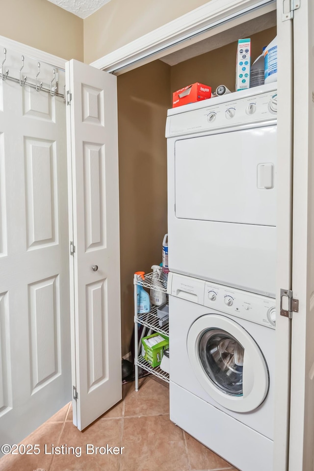 laundry area featuring stacked washer / dryer and tile patterned floors