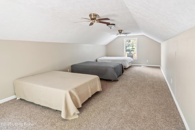 carpeted bedroom with ceiling fan, a textured ceiling, and vaulted ceiling