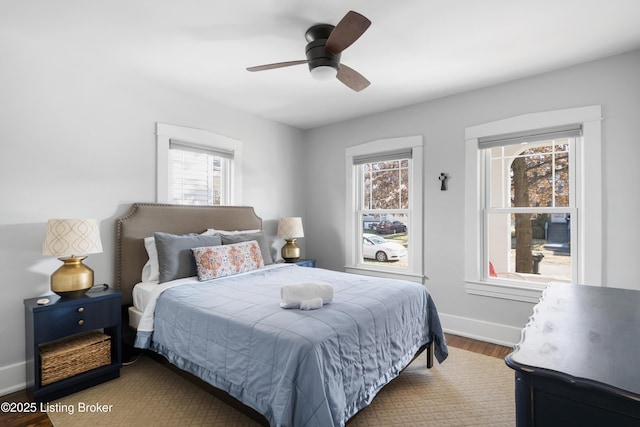 bedroom featuring multiple windows, wood-type flooring, and ceiling fan