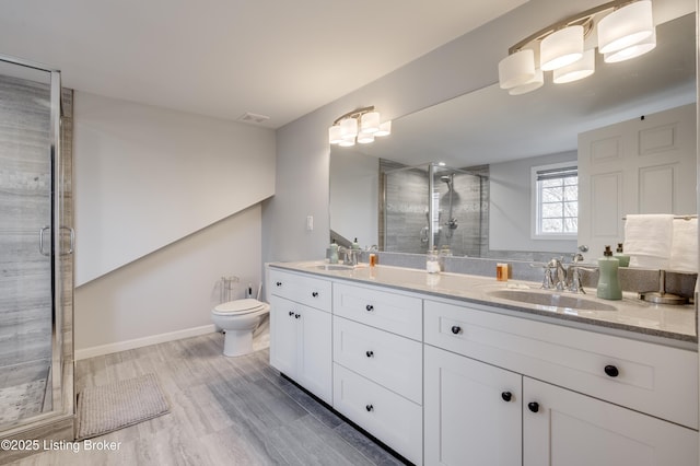 bathroom with a shower with door, vanity, hardwood / wood-style floors, and toilet