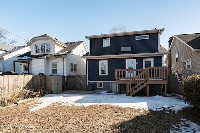 rear view of property featuring a wooden deck and central AC unit