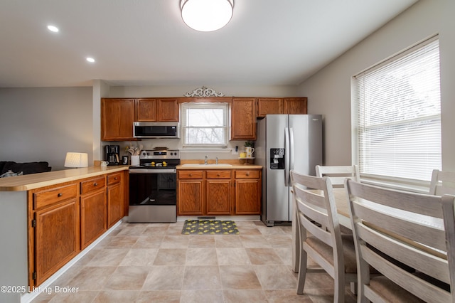 kitchen with sink, kitchen peninsula, and appliances with stainless steel finishes