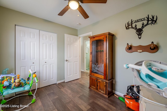 game room with ceiling fan and dark wood-type flooring