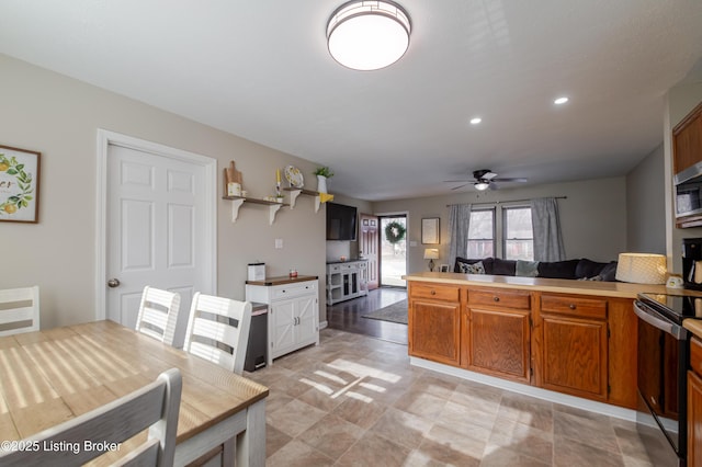 kitchen featuring ceiling fan, kitchen peninsula, and electric stove