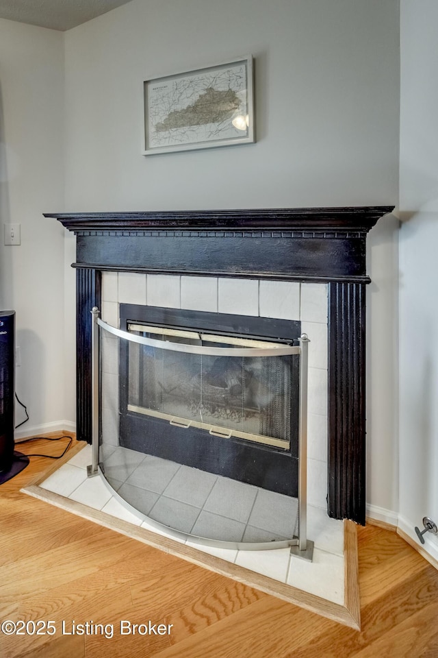 room details with hardwood / wood-style flooring and a tile fireplace