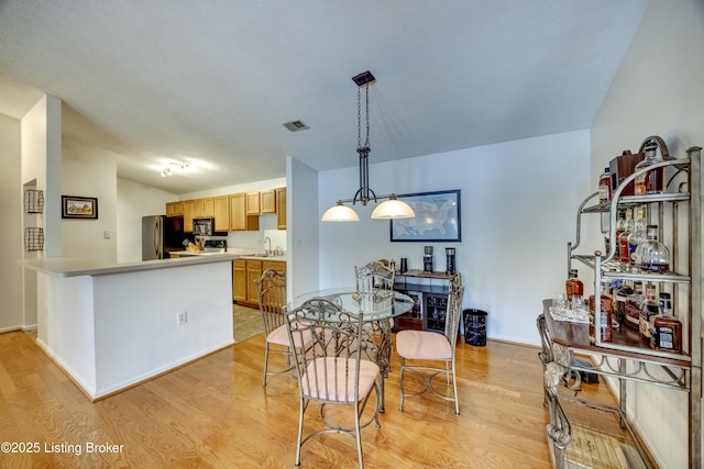 dining area featuring sink and light hardwood / wood-style flooring