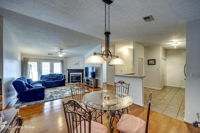 dining room featuring ceiling fan, a textured ceiling, and light wood-type flooring