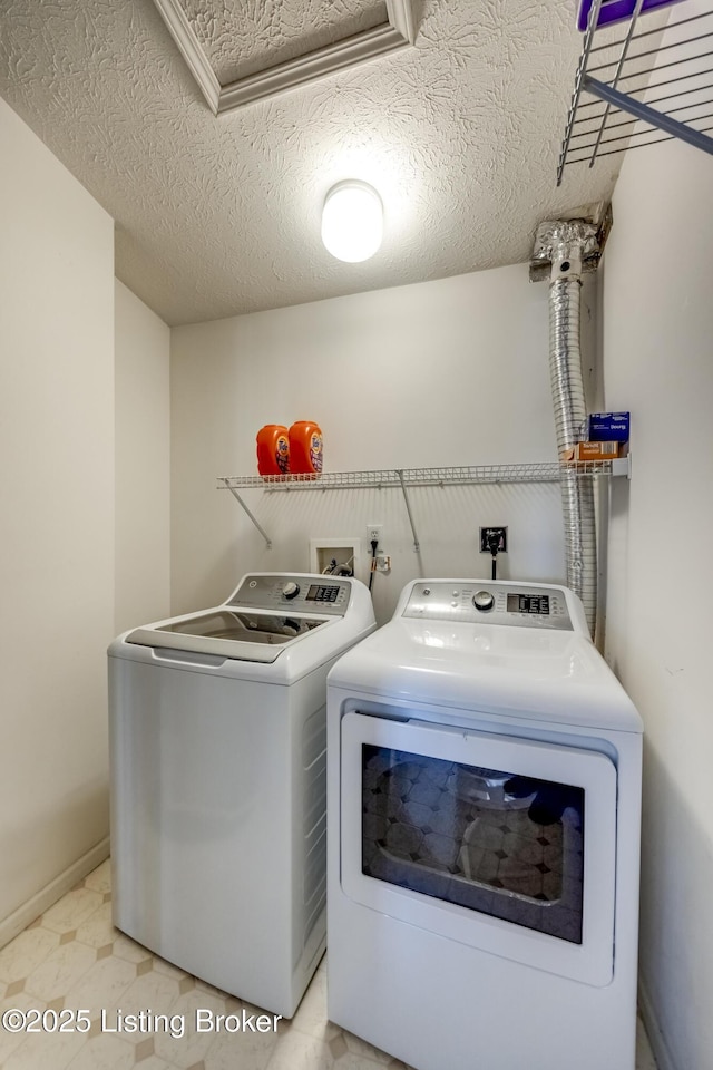 washroom featuring washing machine and dryer and a textured ceiling