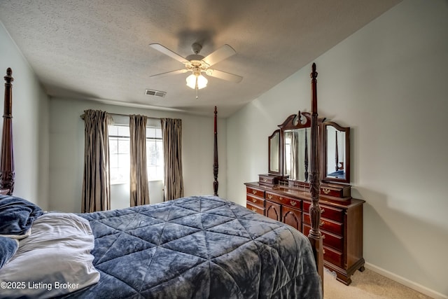 carpeted bedroom with ceiling fan and a textured ceiling