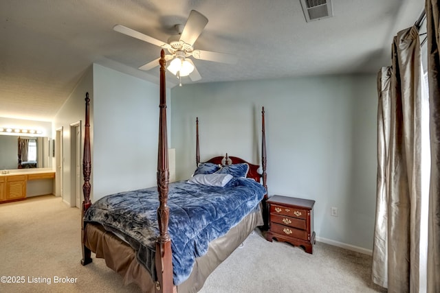 carpeted bedroom featuring vaulted ceiling, ceiling fan, and ensuite bath