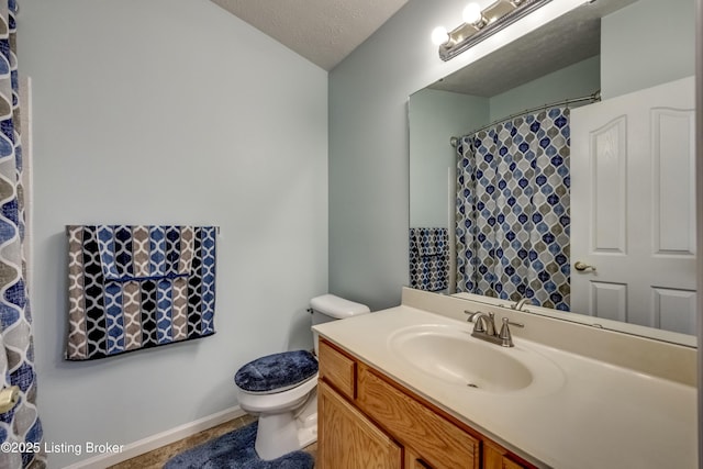 bathroom featuring vanity, toilet, and a textured ceiling