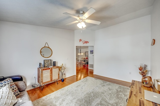 living area with hardwood / wood-style flooring and ceiling fan