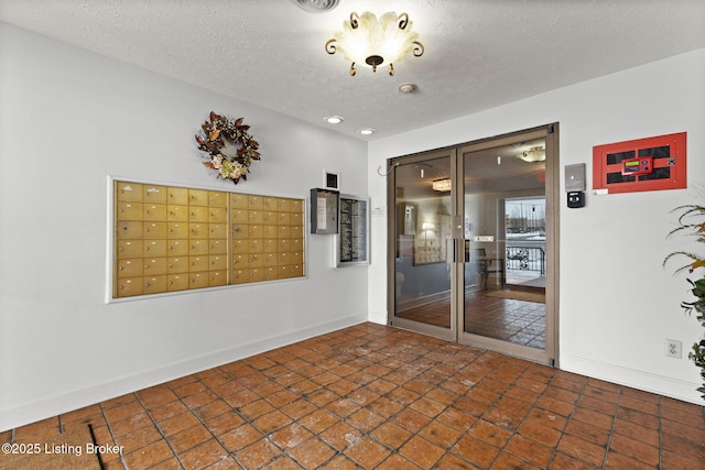 empty room featuring a mail area and a textured ceiling