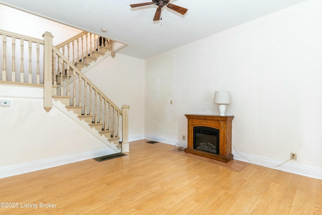 unfurnished living room featuring hardwood / wood-style flooring and ceiling fan