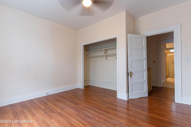 unfurnished bedroom with a closet, ceiling fan, and hardwood / wood-style flooring