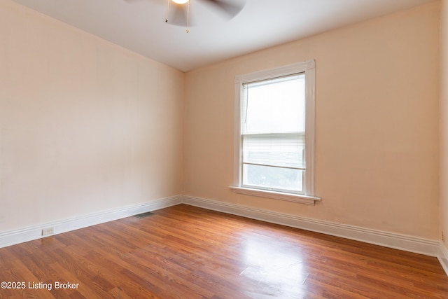 spare room with wood-type flooring, plenty of natural light, and ceiling fan