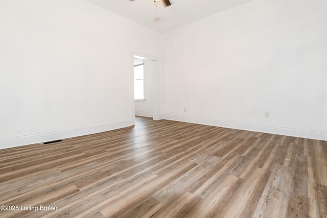 empty room with light wood-type flooring and ceiling fan