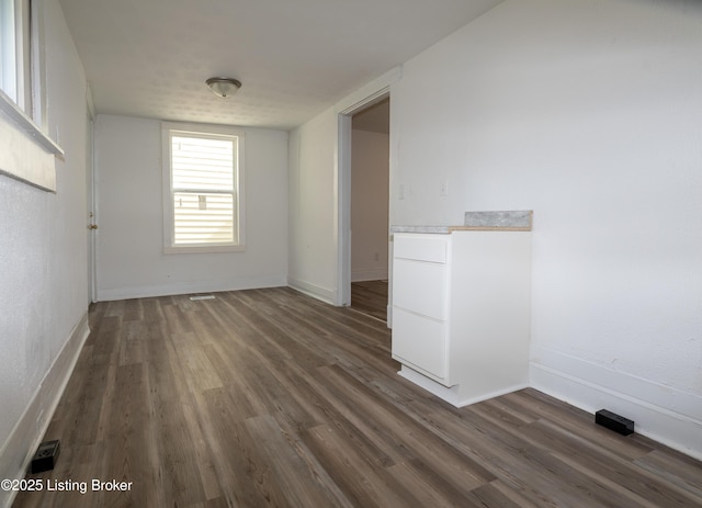 unfurnished room with dark wood-type flooring