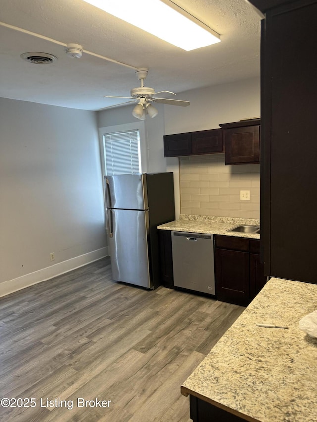 kitchen with light wood finished floors, visible vents, light countertops, decorative backsplash, and appliances with stainless steel finishes