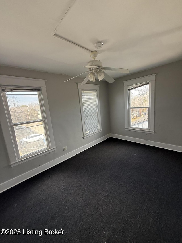 spare room with baseboards and ceiling fan