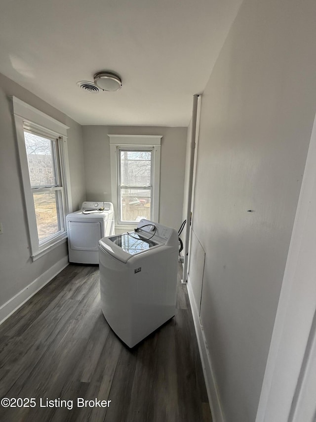 laundry room featuring visible vents, washing machine and dryer, a wealth of natural light, laundry area, and dark wood-style flooring