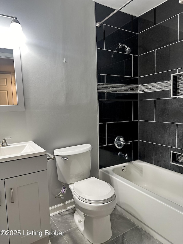 full bathroom featuring toilet, tiled shower / bath, and vanity