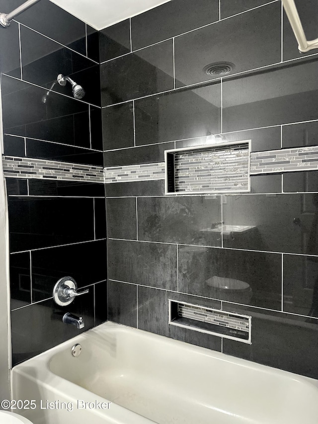 bathroom featuring tiled shower / bath