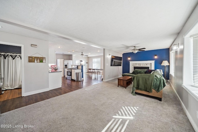 carpeted living room with a textured ceiling and ceiling fan