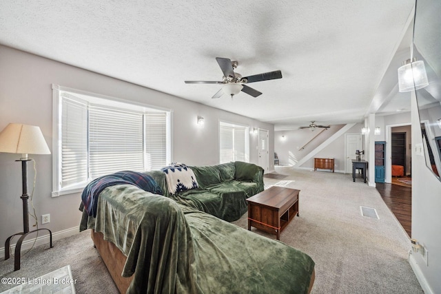 carpeted living room with a textured ceiling and ceiling fan