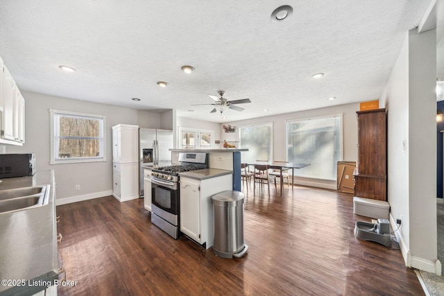 kitchen with sink, white cabinetry, stainless steel appliances, and a healthy amount of sunlight