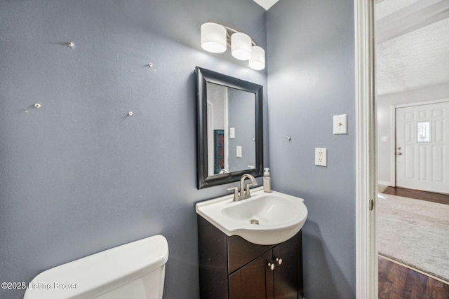 bathroom featuring hardwood / wood-style floors, toilet, and vanity