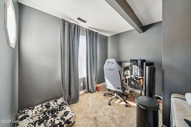 carpeted office space with a textured ceiling, beam ceiling, and a healthy amount of sunlight