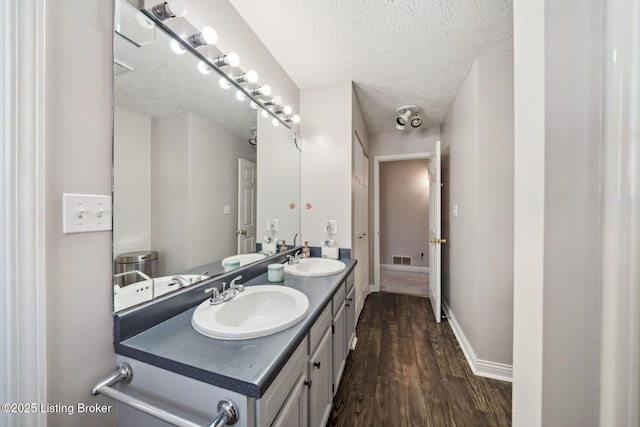 bathroom with wood-type flooring, a textured ceiling, and vanity