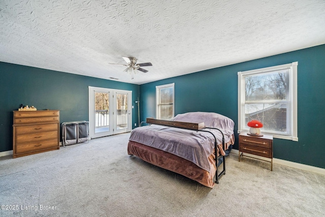 carpeted bedroom featuring ceiling fan, access to outside, and a textured ceiling