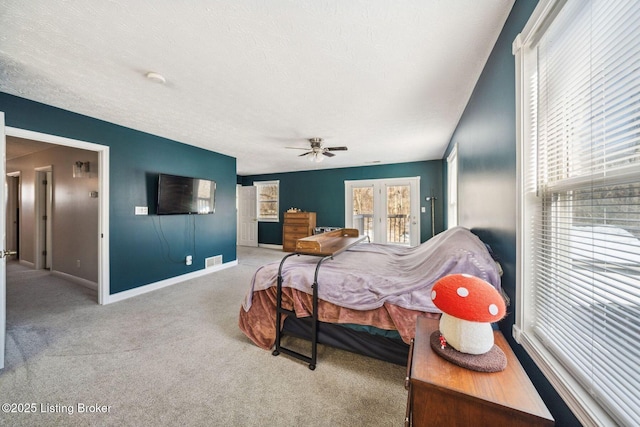 bedroom featuring a textured ceiling, light colored carpet, and ceiling fan