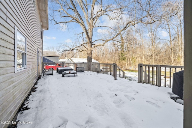 yard covered in snow with a wooden deck