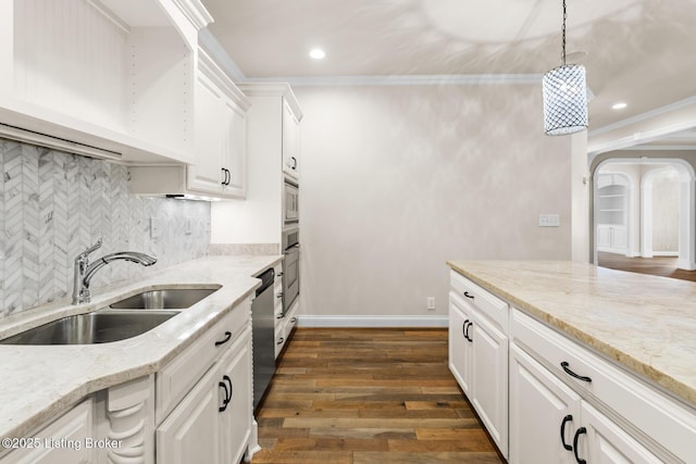 kitchen featuring sink, white cabinetry, stainless steel appliances, light stone counters, and decorative light fixtures