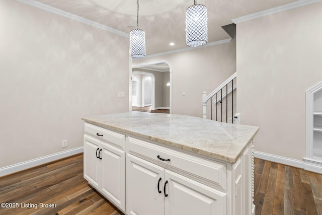 kitchen featuring pendant lighting, white cabinetry, crown molding, and dark hardwood / wood-style floors