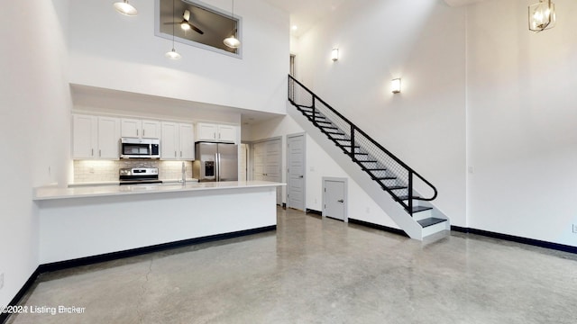 kitchen featuring ceiling fan, appliances with stainless steel finishes, white cabinetry, and pendant lighting