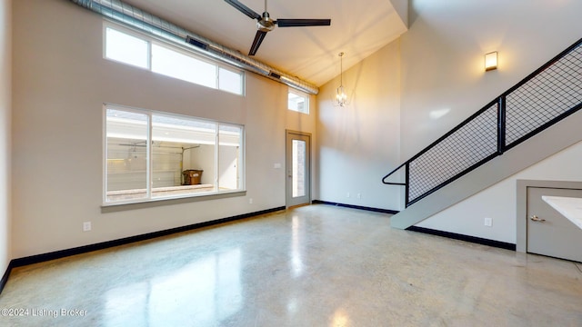 foyer entrance featuring ceiling fan with notable chandelier and a towering ceiling